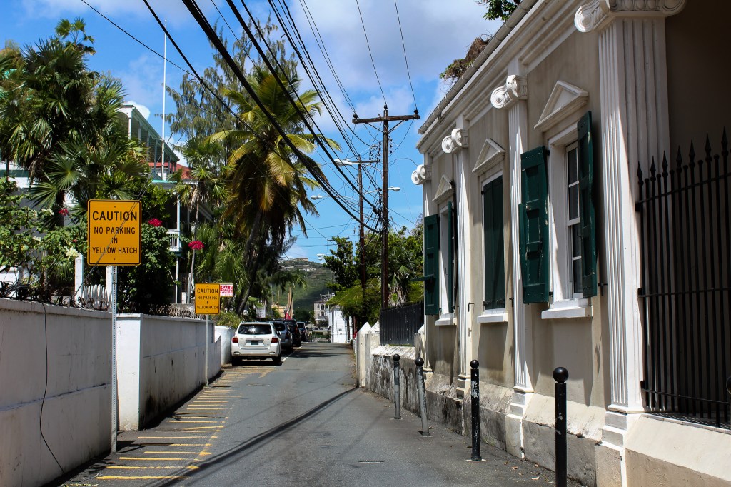 city street with signs, buildings and palm trees